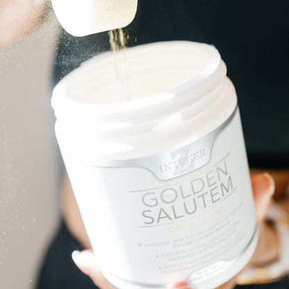 Open Golden salutem  with scoop pouring powder back into tub being help by a woman with white nails and she is wearing black