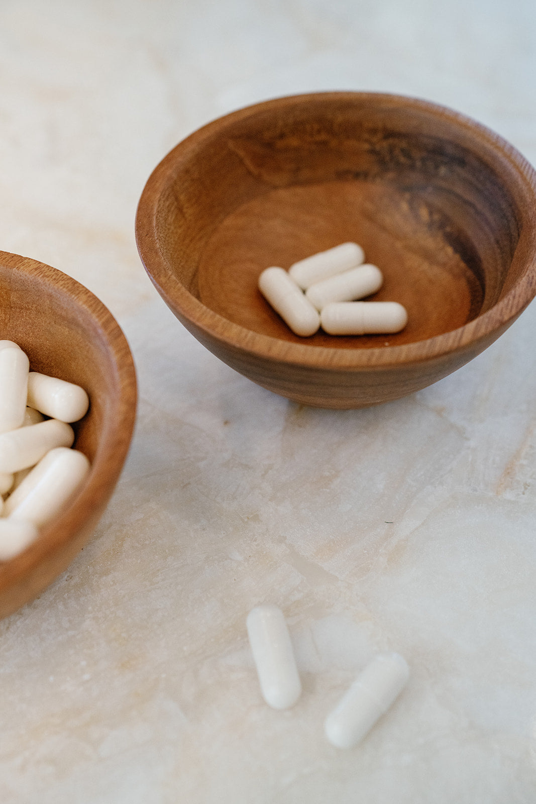 Sleeping aid capsules in wooden bowl on granite countertop 